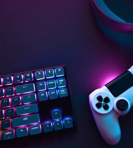 Top down view of colorful illuminated gaming accessories laying on table. Professional computer game playing, esport business and online world concept.